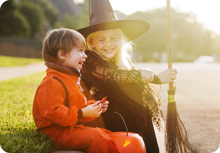 Two Kids In Halloween Costumes Sitting