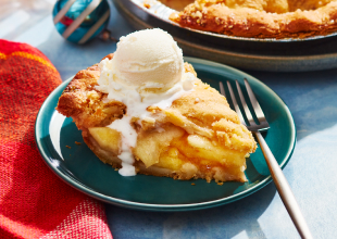 Pumpkin and apple pie in pie plates with slices cut out of them